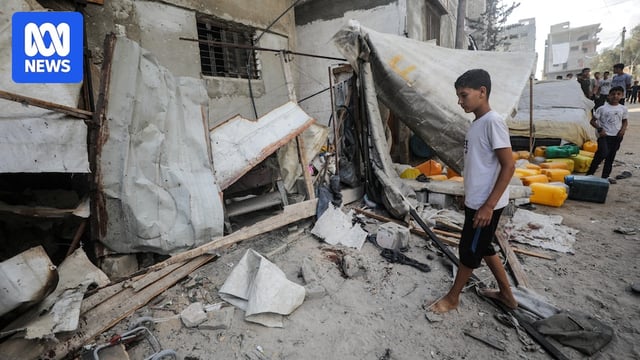 A Palestinian boy inspects the site of an Israeli strike that killed Palestinians in Gaza