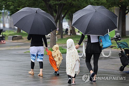 People move to avoid the rain while enjoying playing in water in Yeouido, Seoul, on July 13, 2025. (Yonhap)