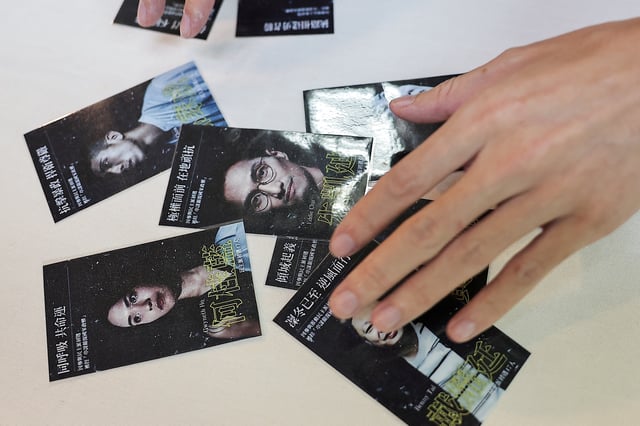 Sky Fung, Secretary-General, Hong Kong Outlanders, shows cards with pictures of activists as he holds a press conference in Taipei, Taiwan November 20, 2024. REUTERS/Ann Wang/File photo