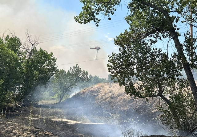 A helicopter dumps water on a wildfire in Douglas County near Chatfield State Park on Sunday, July 13, 2025. (Photo courtesy of South Metro Fire Rescue)