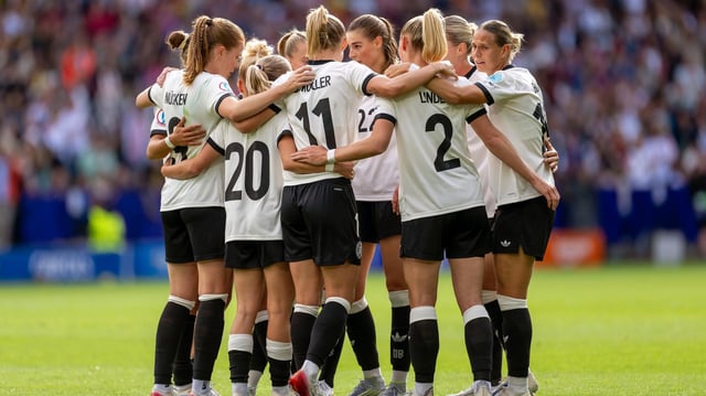 Die deutschen Nationalspielerinnen stehen bei der EM auf dem Rasen im Kreis zusammen.