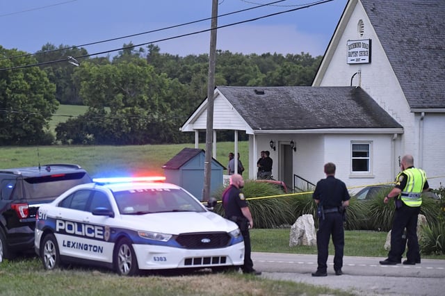 Police stand at the front of the Richmond Road Baptist Church following a shooting Sunday in Lexington, Ky.