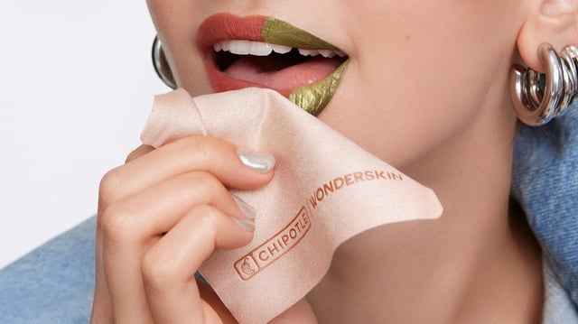 Chipotle and Wonderskin have partnered to re-release their "Lipotle" lip stain. The metallic green stain peels off to reveal nude-pink lip color. The lip stain is available exclusively on the Wonderskin website, starting July 15, 2025.