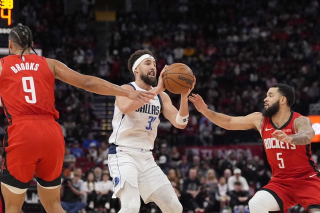 Dallas Mavericks&#39; Klay Thompson (31) shoots as Houston Rockets&#39; Fred VanVleet (5) and Dillon Brooks (9) defend during the first half of an NBA basketball game Wednesday, Jan. 1, 2025, in Houston. 