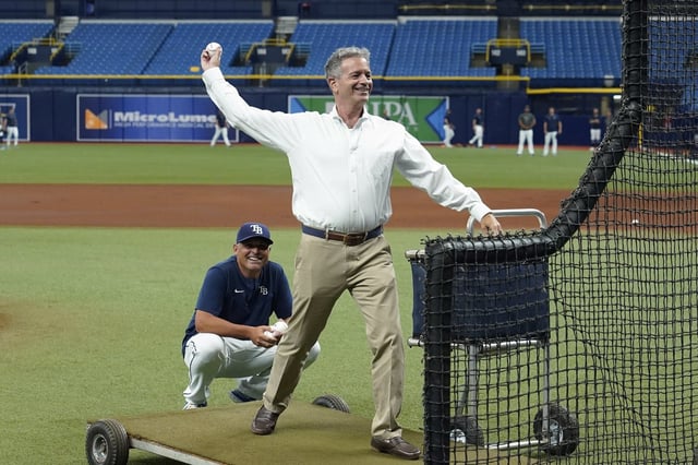 Tampa Bay Rays owner Stuart Sternberg throws batting practice before a baseball game against the Cleveland Guardians Friday, July 29, 2022, in St. Petersburg, Fla. Looking on is manager Kevin Cash. (AP Photo/Chris O&#39;Meara)