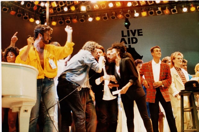 The Live Aid concert at Wembley Stadium, London, England, on July 13, 1985. From left are George Michael of Wham, Bob Geldolf, Bono of U2, Freddie Mercury of Queen, Helena Springs (backup singer for David Bowie), Andrew Ridgley of Wham! and Howard Jones. The full concert is now streaming online, and new CNN and BBC documentaries exploring its legacy.