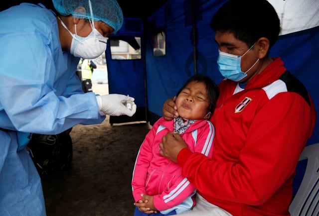 A little girl reacts after receiving an oral vaccine during a vaccination drive for diphtheria, influenza, tetanus and pneumococcus, after several new cases of diphtheria were identified, as the coronavirus disease (COVID-19) outbreak continues, in Lima, Peru November 7, 2020. REUTERS/Sebastian Castaneda     TPX IMAGES OF THE DAY
