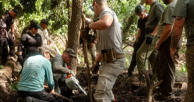 Law enforcement officials and volunteers clear up mountains of debris deposited by the flood in Center Point on Tuesday July 8, 2025.