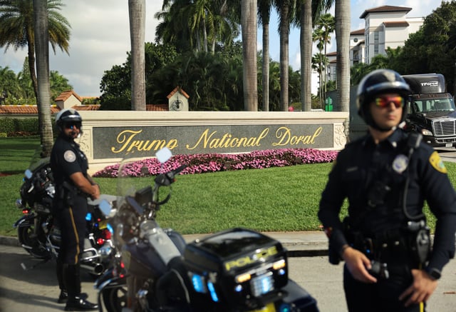 Police keep watch as the motorcade of U.S. President Donald Trump arrives at Trump National Doral golf club in Miami, Florida, U.S., February 19, 2025. REUTERS/Kevin Lamarque/File Photo