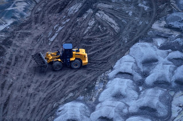 An earth mover transports soil at a construction site in Beijing, China, Friday, July 11, 2025. (AP Photo/Mahesh Kumar A.)