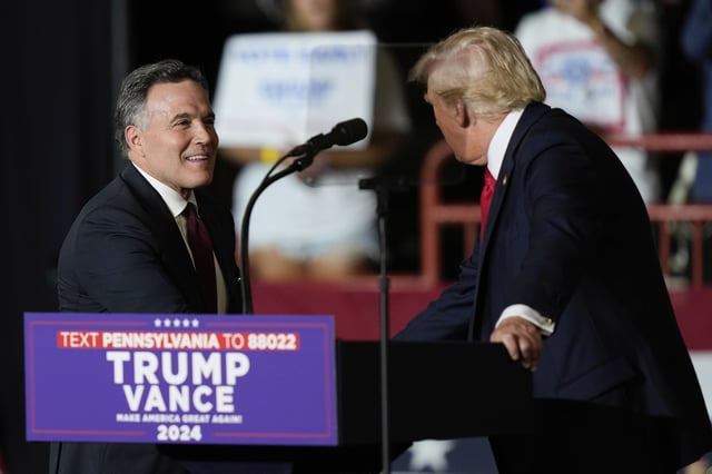 FILE - Republican Pennsylvania Senate candidate David McCormick, left, walks on stage to greet Republican presidential candidate former President Donald Trump, at a rally in Harrisburg, Pa., July 31, 2024. (AP Photo/Matt Rourke, File)