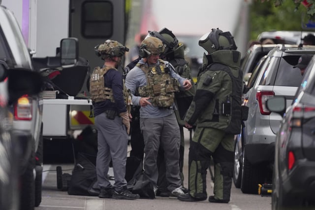 FILE - Law enforcement officials dress up in protective gear to investigative an attack on the Pearl Street Mall, June 1, 2025, in Boulder, Colo. (AP Photo/David Zalubowski, FIle)