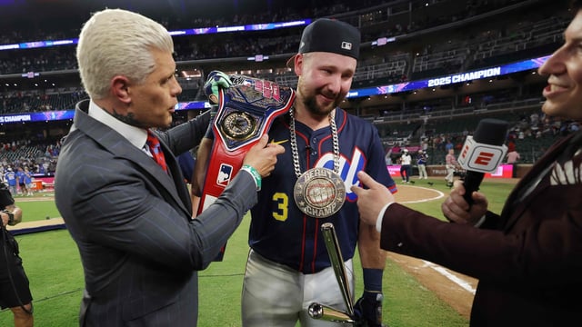 Cal Raleigh #29 of the Seattle Mariners receives the championship belt from professional wrestler Cody Rhodes after winning the Home Run Derby 