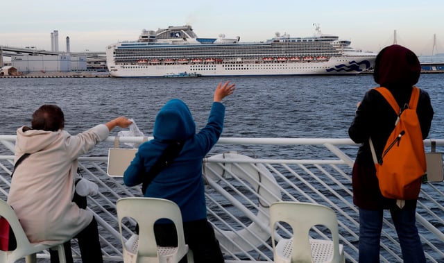Tourists on a sightseeing cruise ship wave to passengers of the cruise ship Diamond Princess, which is anchored at Daikoku Pier Cruise Terminal in Yokohama, south of Tokyo, Japan February 12, 2020. REUTERS/Kim Kyung-hoon/File Photo