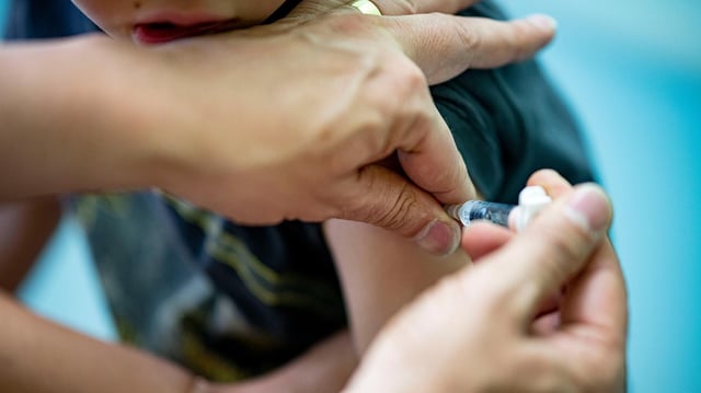 Ein Kinderarzt verabreicht einem Jungen einem Auffrischung eines dtp-Kombinationsimpfstoff.