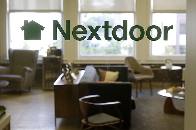 FILE - A Nextdoor sign is shown on a window at an office in San Francisco on May 11, 2016. (AP Photo/Jeff Chiu, File)