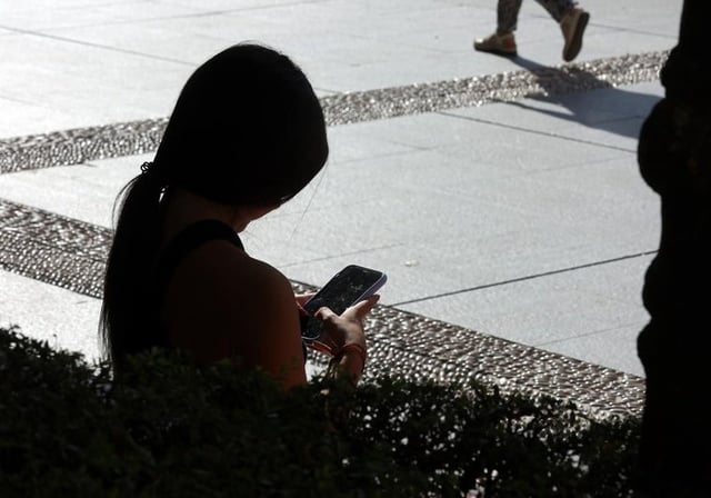 Una joven con el móvil en el centro de la capital en una imagen de archivo