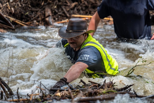 Brandon Myrtle stands in the Guadalupe River as he tries to clear debris after catastrophic floods in Center Point, Texas, on July 11, 2025.