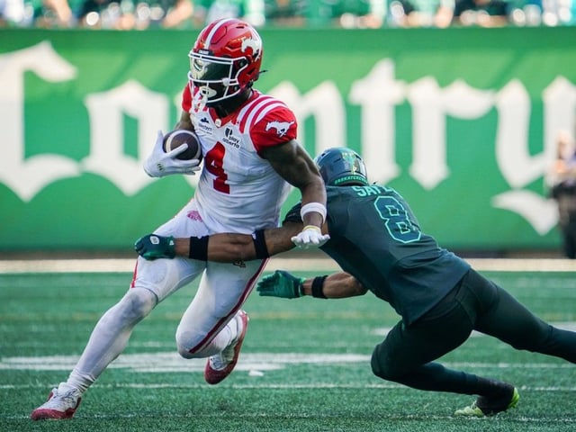 Saskatchewan Roughriders defensive back Marcus Sayles (8) tackles Calgary Stampeders receiver Tevin Jones (4) as he runs the football during the second half of CFL football action in Regina, on Saturday, July 12, 2025.