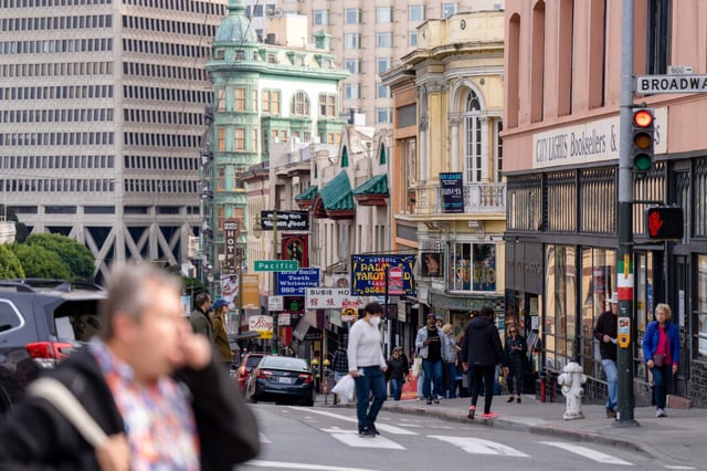 Pedestrians cross the street Broadway and walk down Columbus Avenue in the North Beach neighborhood of San Francisco. COVID-19 is once again on the rise in California, according to wastewater surveillance data and CDC estimates. 