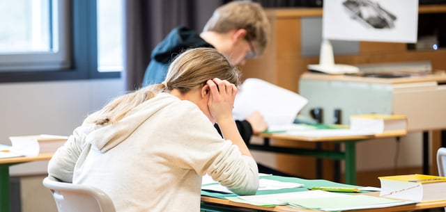 Schülerinnen und Schüler sitzen während einer schriftlichen Abiturprüfung in einem Klassenzimmer (Symbolbild)