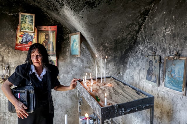 Une chrétienne allume une bougie dans l'église Saint-Georges du Ve siècle dans le village chrétien palestinien de Taybeh, au nord-est de Ramallah en Cisjordanie occupée, le 14 juillet 2025