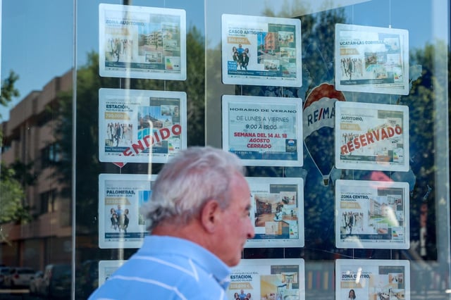 Archivo - Un hombre camina frente a un escaparate de anuncios de viviendas, en Madrid (España)
