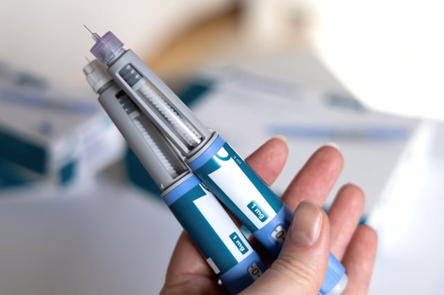 A stock image shows a person holding Ozempic Insulin injection pens for diabetes/ weight loss.