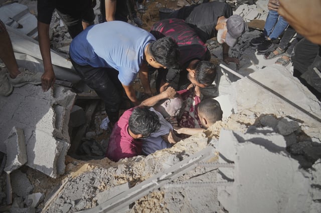 EDS NOTE: GRAPHIC CONTENT - The body of a man is recovered from the rubble of a house following an Israeli military strike in Gaza City, Tuesday, July 15, 2025. (AP Photo/Jehad Alshrafi)