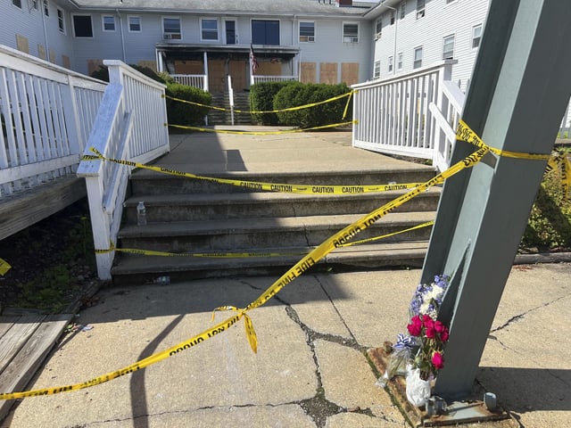 Flowers sit in front of the Gabriel House assisted living facility where a fire on Sunday killed several people, Tuesday, July 15, 2025 in Fall River, Mass. (AP Photo/Kimberlee Kruesi)