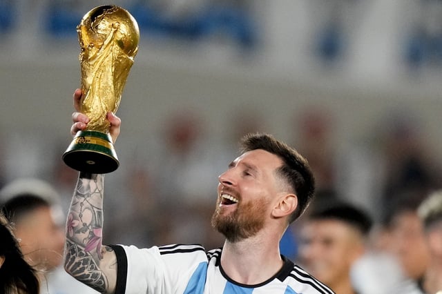 Argentina's Lionel Messi hoists the FIFA World Cup trophy during a celebration ceremony for local fans after an international friendly soccer match against Panama at the Monumental stadium in Buenos Aires, Argentina, Thursday, March 23, 2023. (AP Photo/Natacha Pisarenko)