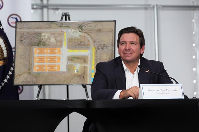 Gov. Ron DeSantis, R-Fla., listens during a roundtable at &#34;Alligator Alcatraz,&#34; a new migrant detention facility at Dade-Collier Training and Transition facility, Tuesday, July 1, 2025, in Ochopee, Fla. (AP Photo/Evan Vucci)