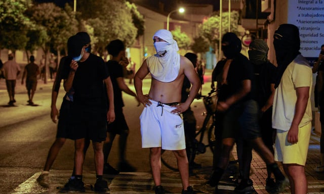 Des habitants se sont rassemblés dans la rue après trois jours de troubles à Torre Pacheco, dans l'est de l'Espagne, le 14 juillet 2025. La police espagnole a arrêté dix personnes à la suite des émeutes anti-migrants ont annoncé les autorités lundi.