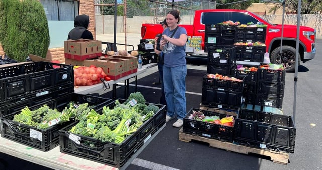 El periodista Dan Frosch inicia su historia en Albuquerque, Nuevo México. Con Sarah Aragón, que observa la creciente fila de personas que serpentea por la Avenida Central, esperando su ración de alimentos: melones, frijoles pintos, bagre congelado. Foto: Facebook Sisters' Food Project