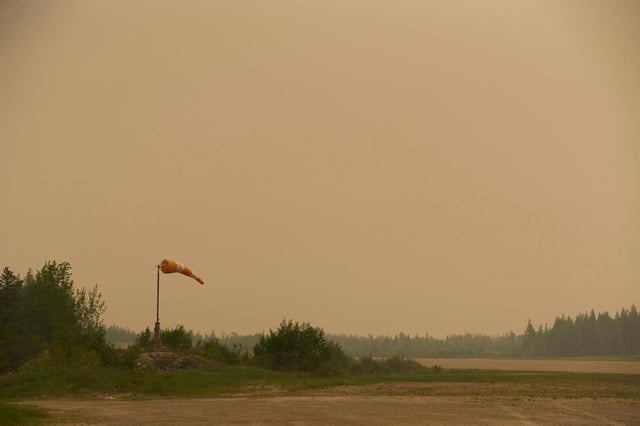 Smoke filled skies from out of control wildfires in Norway House, Manitoba Tuesday, June 3, 2025, at the Norway House Airport as crews continue to fight wildfires in northern Manitoba. (David Lipnowski/The Canadian Press via AP)