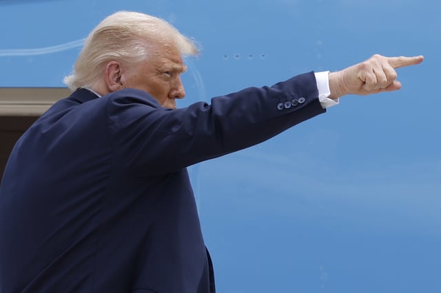 President Donald Trump gestures from the stairs of Air Force One as he boards upon his arrival at Joint Base Andrews, Md., Tuesday, July 15, 2025. (AP Photo/Luis M. Alvarez