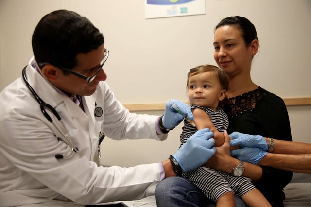 Daniela Chavarriaga holds her daughter, Emma Chavarriaga, as pediatrician Jose Rosa-Olivares, M.D. administers a measles vaccination during a visit to the Miami Children's Hospital on June 2, 2014, in Miami, Florida.