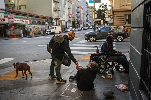 Tyler Charlton, who is 11-months sober, walks with his dog Freki as he passes out Narcan, through the Tenderloin in San Francisco in November. The neighborhood has a disproportionate number of homeless shelters, but proposed legislation aims to place more of them in other neighborhoods.