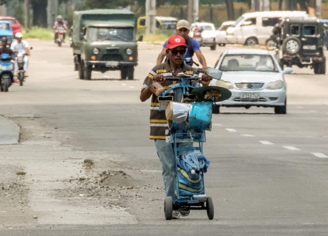 Un anciano empuja un carro lleno de instrumentos musicales caseros para ganarse la vida en las calles de La Habana