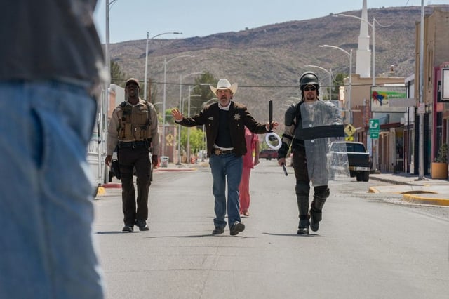 Sheriff Joe Cross (Joaquin Phoenix, center) and his deputies (Michael Ward, left, and Luke Grimes) advance toward demonstrators in “Eddington.”