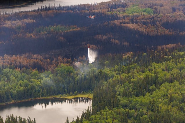 A helicopter crew works on a wildfire in northern Manitoba during a helicopter tour in the surrounding area of Flin Flon, Man. on Thursday, June 12, 2025. THE CANADIAN PRESS/Mike Deal-Pool