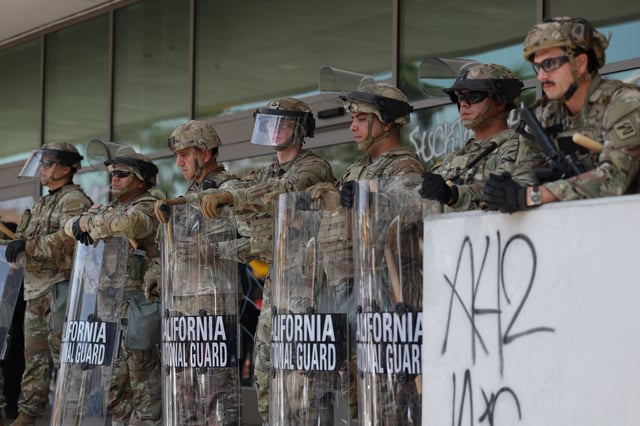 California National Guard members protect the Federal Building following protests triggered by immigration raids, in Los Angeles, on June 9, 2025. Police ordered the public to disperse from downtown Los Angeles on June 8 after further unrest, with cars torched and security forces firing tear gas at protesters, in the wake of US President Donald Trump’s deployment of National Guard troops to America’s second-biggest city. Protests in Los Angeles, home to a large Latino population, broke out on June 6, triggered by immigration raids that resulted in dozens of arrests of what authorities say are illegal migrants and gang members. (Photo by Patrick T. Fallon / AFP) (Photo by PATRICK T. FALLON/AFP via Getty Images)