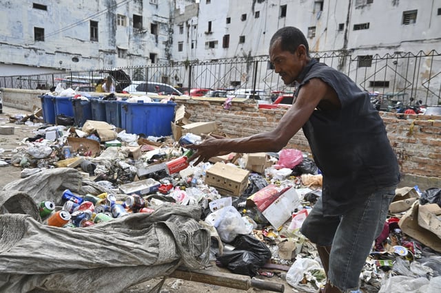 A man culls through garbage collecting aluminium cans for recycling, in Havana, Cuba, Tuesday, July 15, 2025. (AP Photo/Jorge Luis Baños)