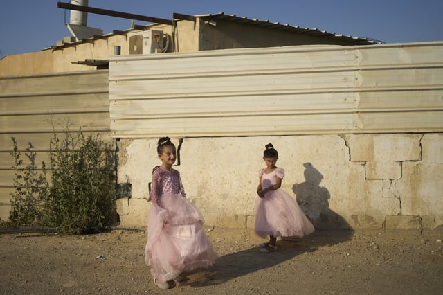 Girls wear fancy dresses for a wedding celebration spanning several days in Al-Zarnug, an unrecognized Bedouin community in the Negev Desert, southern Israel, Wednesday, July 2, 2025. (AP Photo/Maya Alleruzzo)