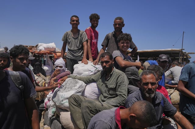Des Palestiniens portant des sacs d’aide humanitaire distribués par la Fondation humanitaire de Gaza (GHF), une association soutenue par les Etats-Unis et Israël, Rafah, Sud de la Bande de Gaza, mercredi 25 juin 2025.