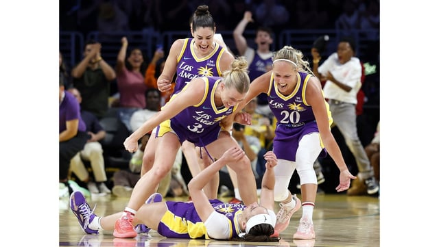 Sparks forward Dearica Hamby, down on the court, celebrates with teammates Julie Vanloo (35), Julie Allemand (20) and Kelsey Plum (10) after making a shot at the buzzer in the first half of their game against the Washington Mystics on Tuesday night at Crypto.com Arena. (Photo by Ronald Martinez/Getty Images)