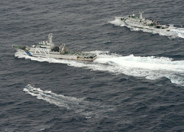 An aerial photo shows Chinese marine surveillance ship Haijian No. 66 (top) trying to approach a Japanese fishing boat (bottom) as Japan Coast Guard vessel Ishigaki cruises next to the Chinese ship, in the East China Sea, near what are known as the Senkaku isles in Japan and the Diaoyu islands in China, in this photo taken on April 23, 2013.