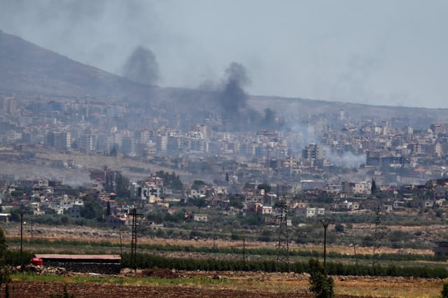 Smoke rise from clashes between Syrian government forces and Druze militias in Sweida city, southern Syria, Tuesday, July 15, 2025. (AP Photo/Omar Sanadiki)