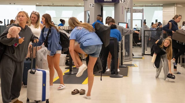 People put their shoes back on as they make their way through the TSA checkpoint at Midway International Airport in Chicago on June 25, 2025. (Audrey Richardson/Chicago Tribune/TNS)