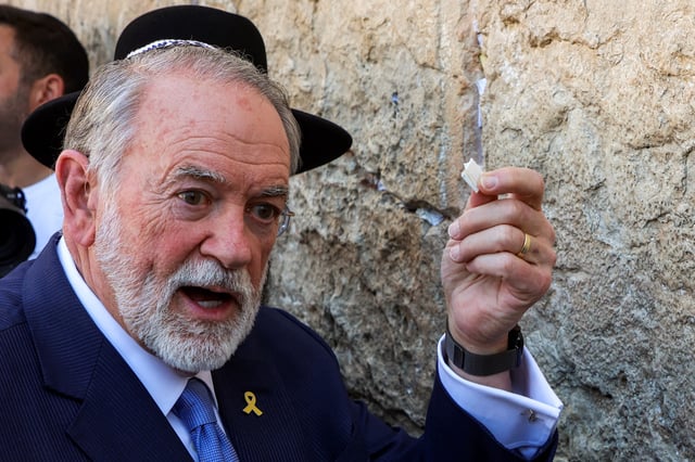 The U.S. Ambassador to Israel Mike Huckabee holds a note given to him from U.S. President Donald Trump to be placed in the cracks of the Western Wall, the holiest site where Jews are allowed to pray, during Huckabee&#39;s visit to the holy site in the old city of Jerusalem on April 18, 2025.